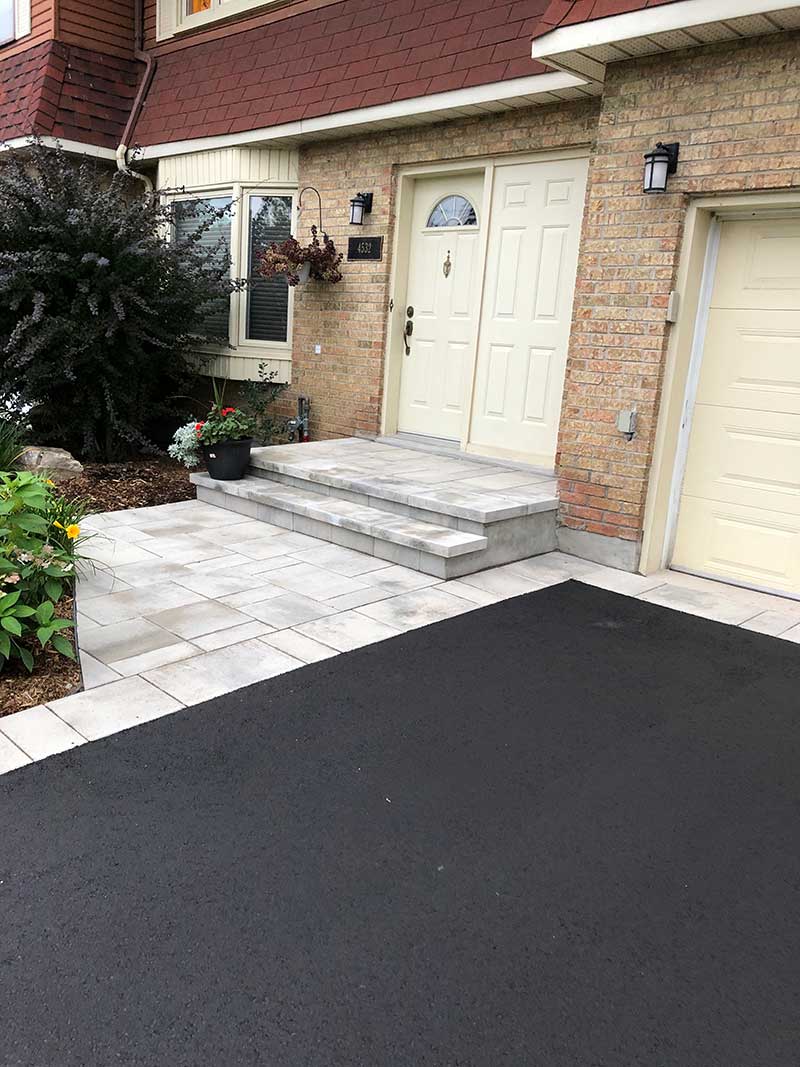 Light grey pavers with asphalt in between with matching paver stairs