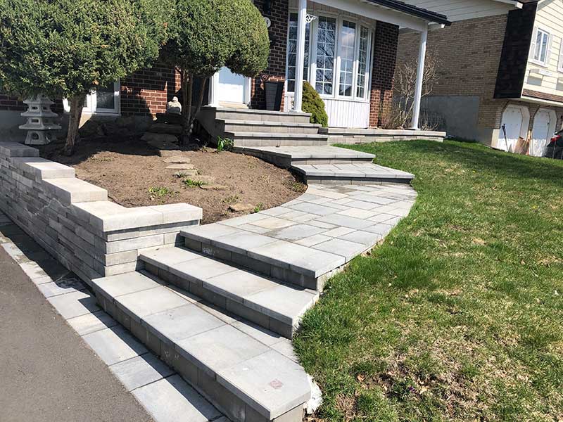 Curvy entrance pavers with modern retaining wall